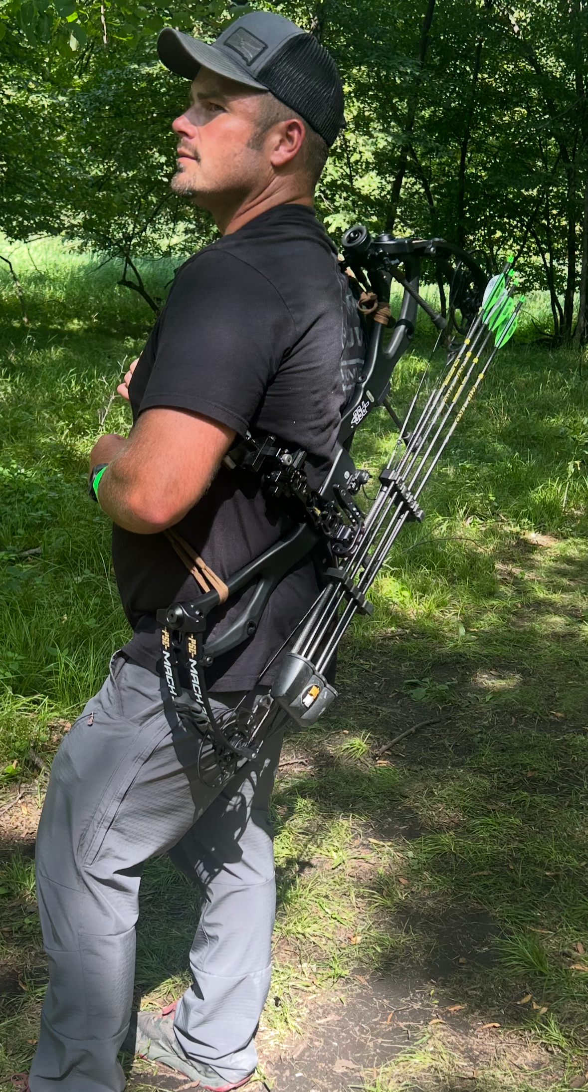 Man with a compound bow and Vsling bow sling in  a forest setting