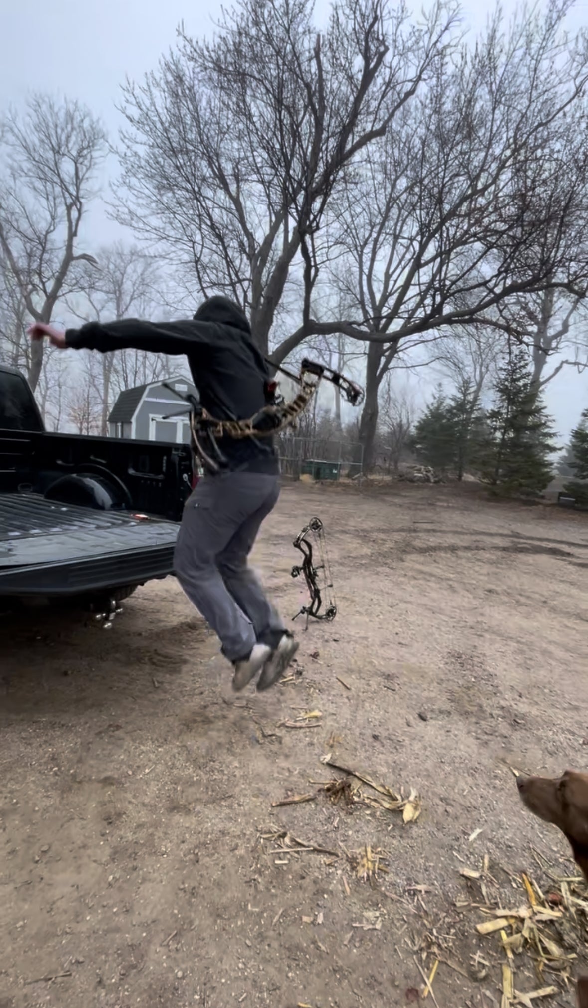 Person with Vsling on Bow jumping into a truck in an outdoor setting