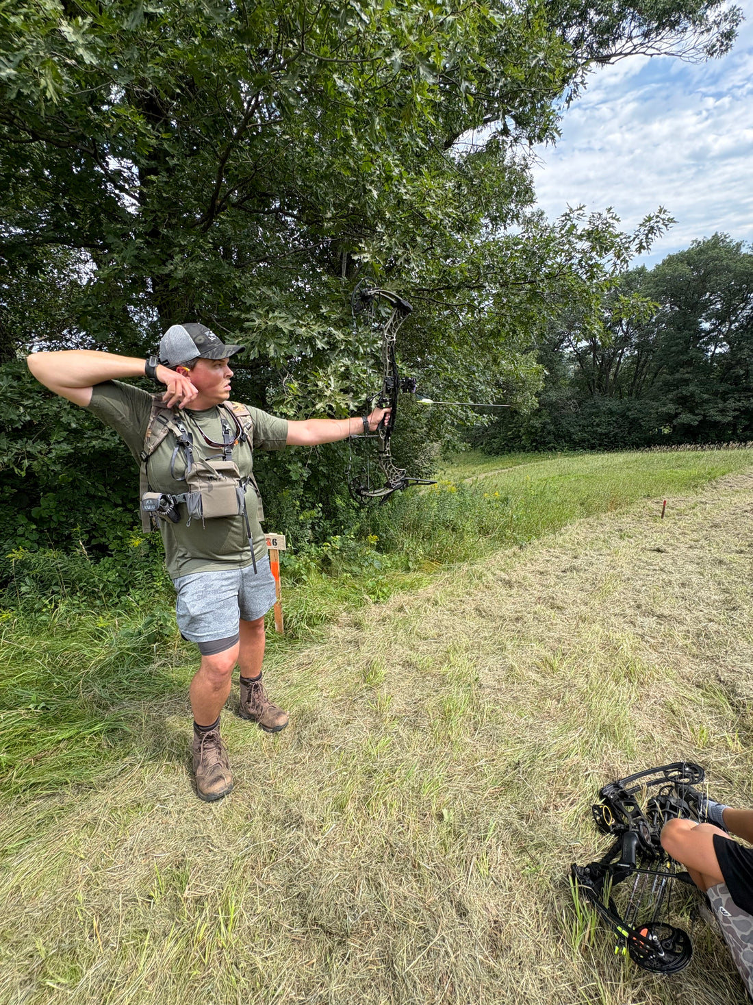Bowhunter carrying compound bow hands-free with Vsling® bow sling in timber