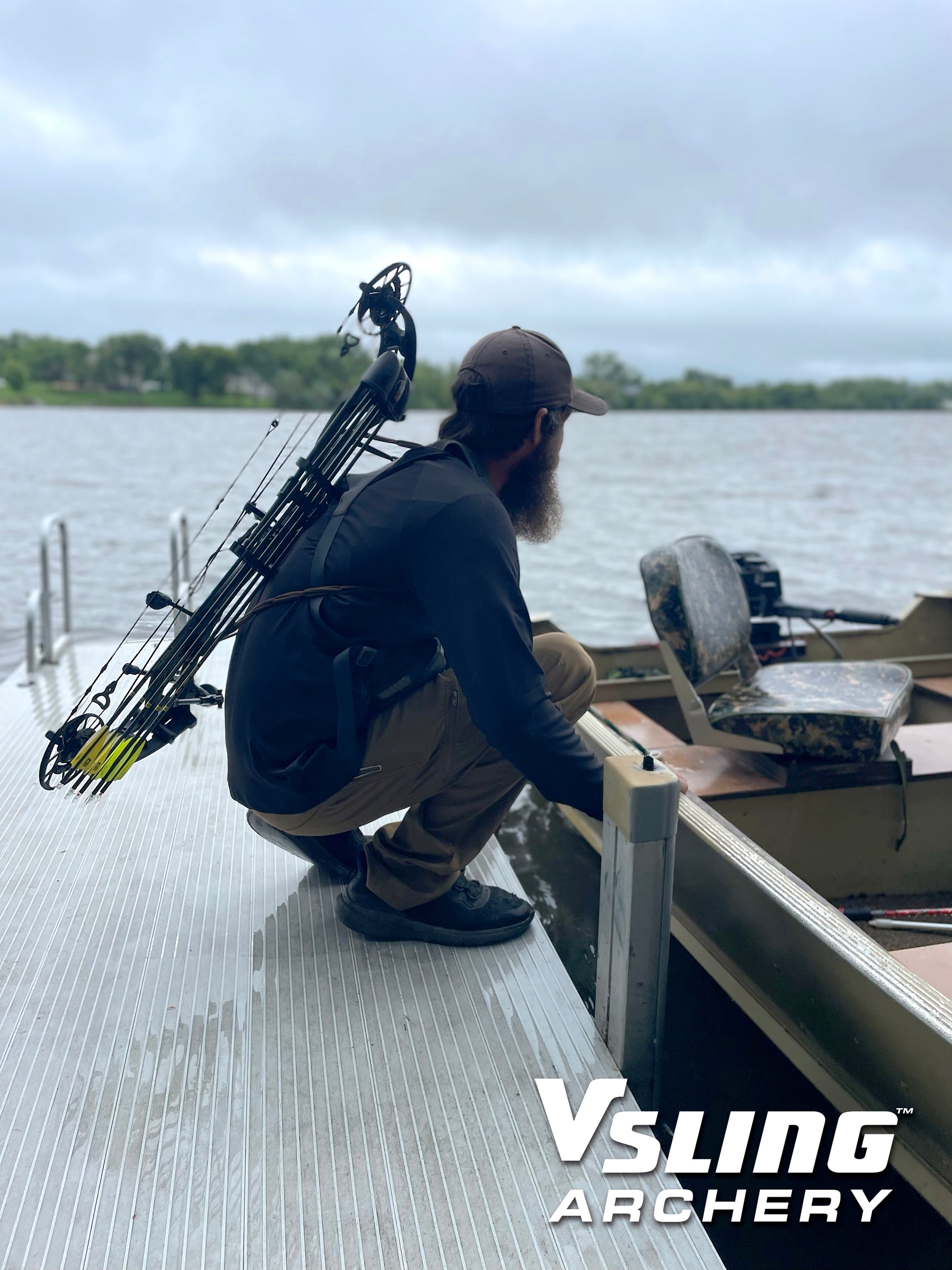 Man with a bow and arrow slung on his back on a dock by a lake, with 'Vsling Archery' branding