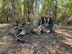 Man with a bow and arrow and Vsling next to a deer he has shot in Austrailia.