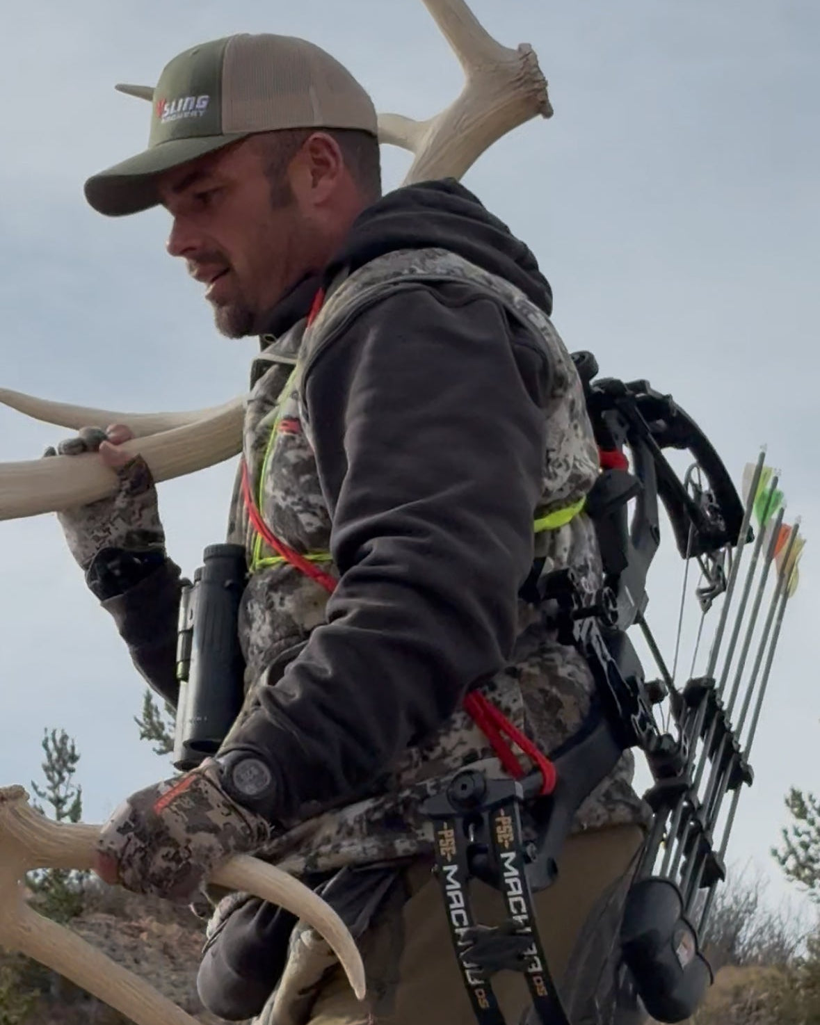 Hunter with archery equipment and deer antlers in a natural setting