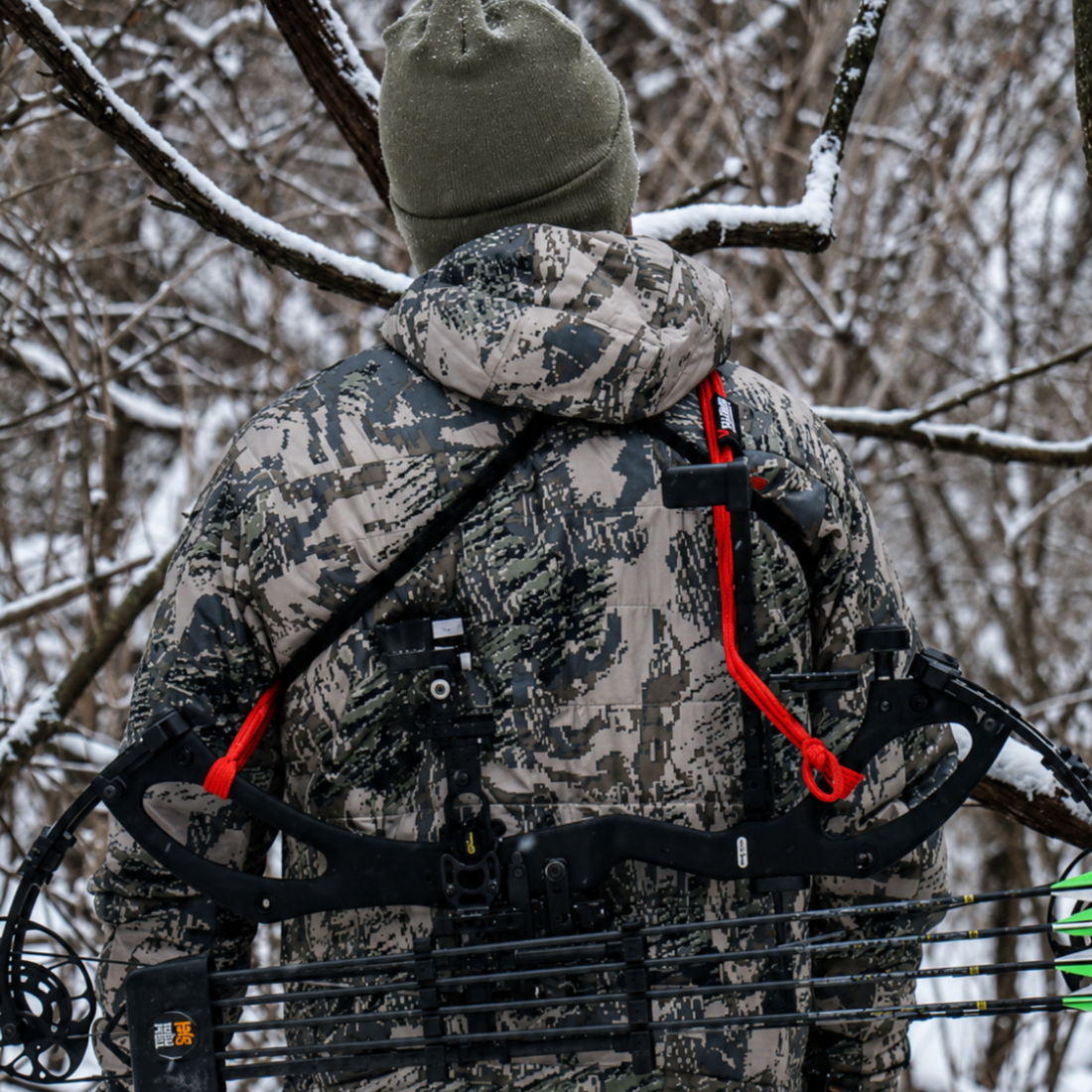 Hunter crossing a fence with Vsling bow sling on a Mathews compound bow in timber.
